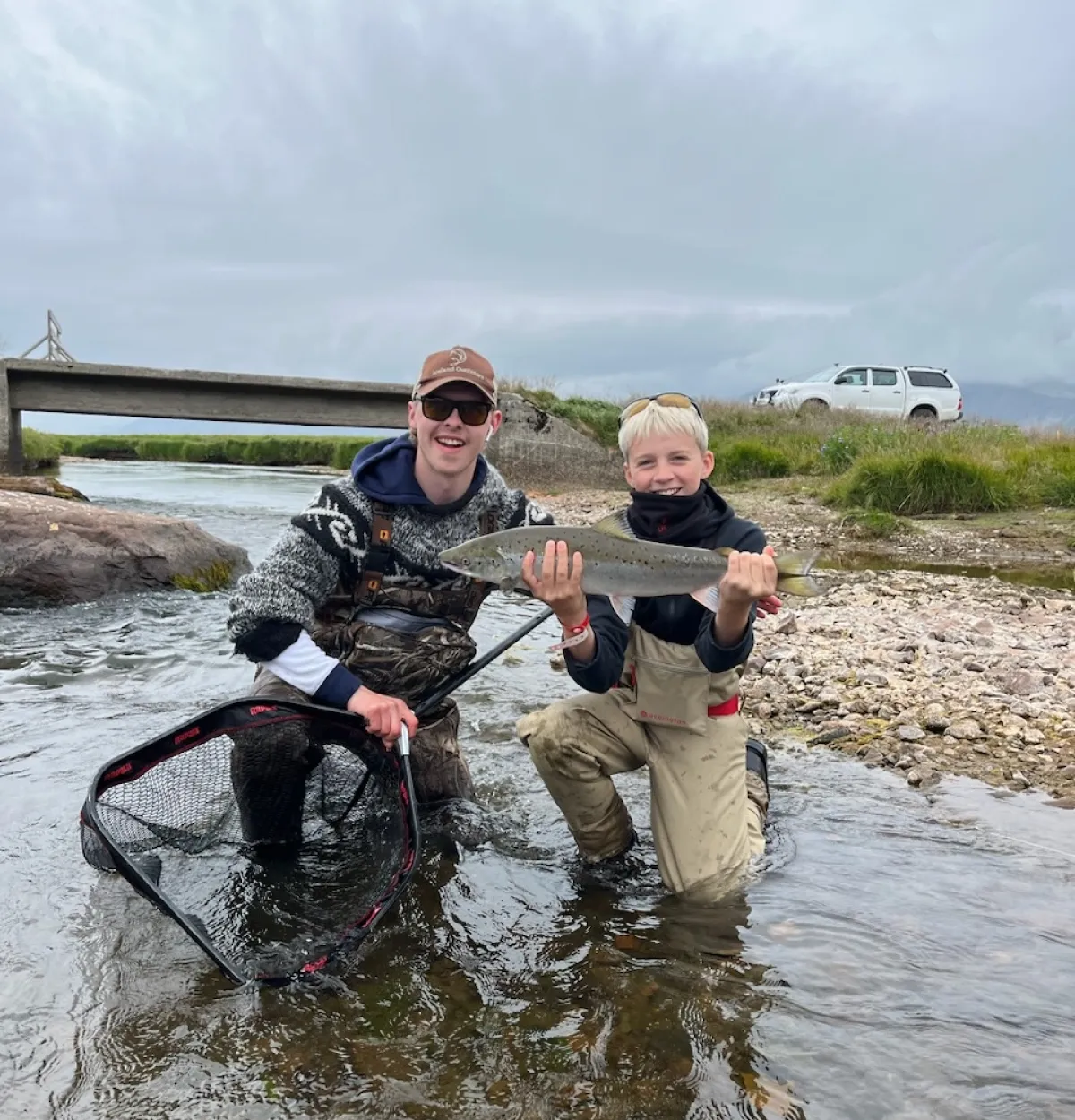 Guide with a kid and his first caught Atlantic Salmon